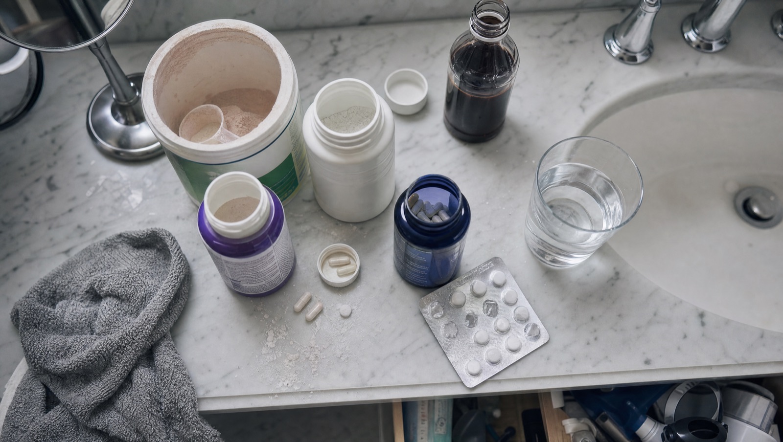 A cluttered counter of failed laxatives, fiber powder, magnesium, and stool softeners